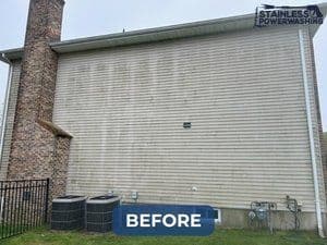 Before power washing: dirty siding on a residential home with visible stains.