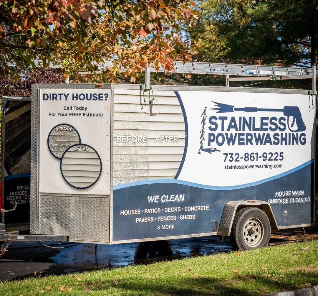 Stainless Powerwashing trailer showcasing before-and-after cleaning services for homes.