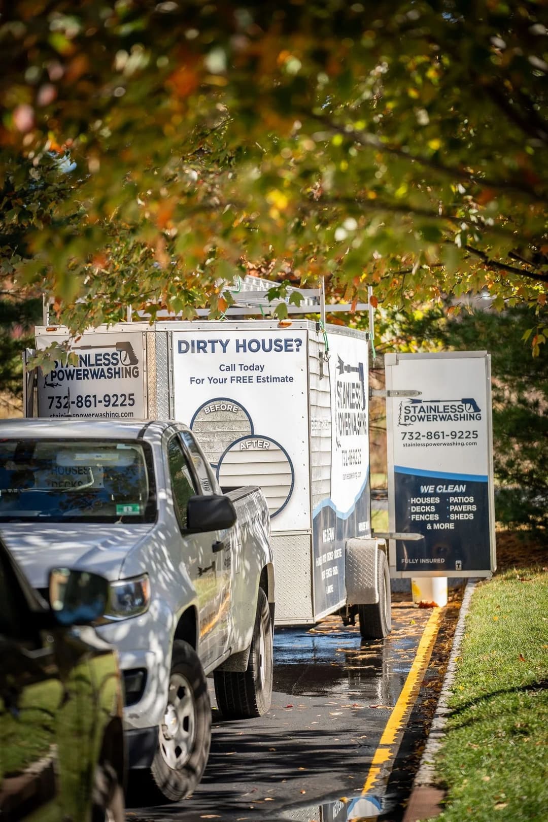 Power washing service trailer parked on a tree-lined street, promoting free estimates.