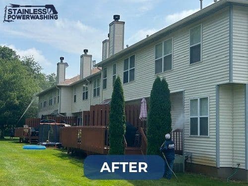 Power washed residential buildings with clean siding and well-maintained decks after service.